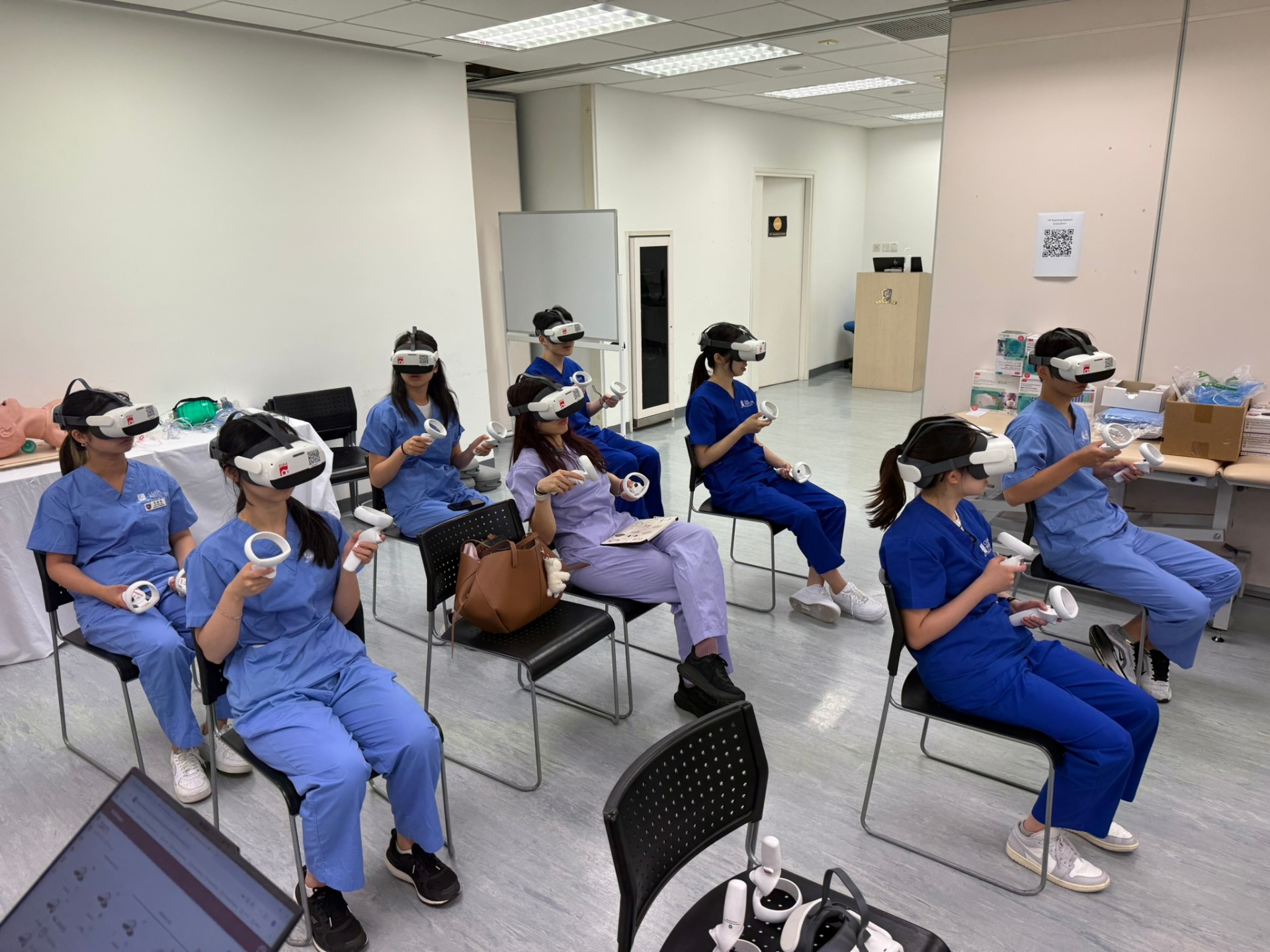 Healthcare students in scrubs using standalone VR headsets during a training workshop